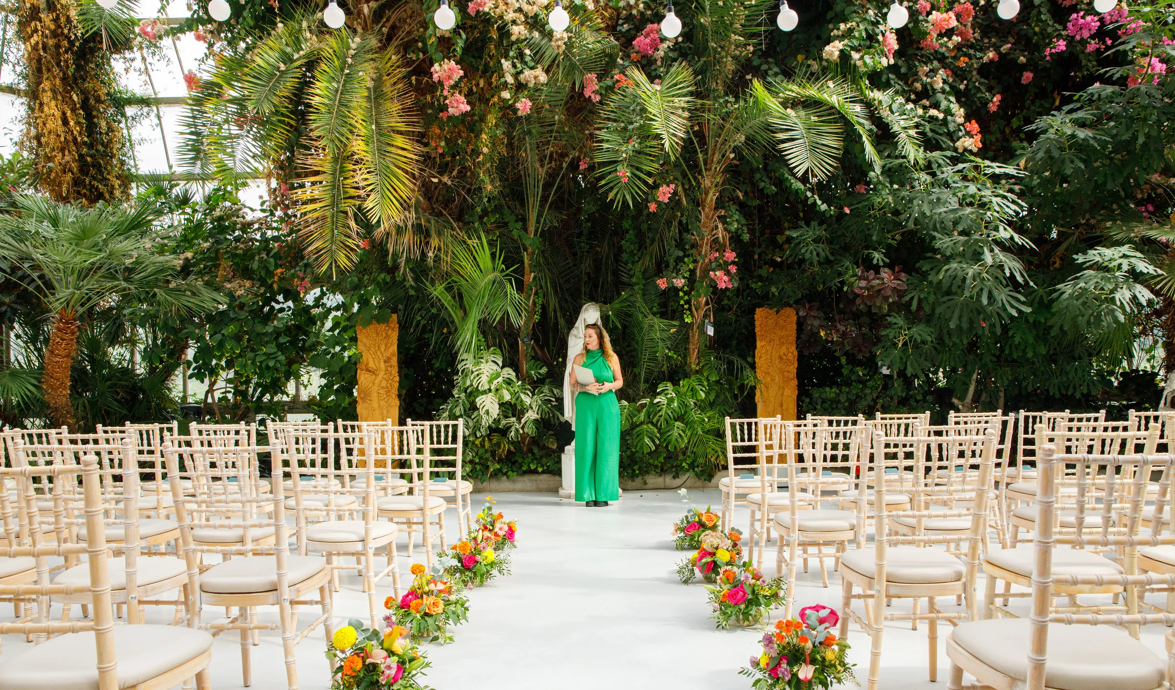 Beth checking the ceremony space beneath the glasshouse palms and flowers