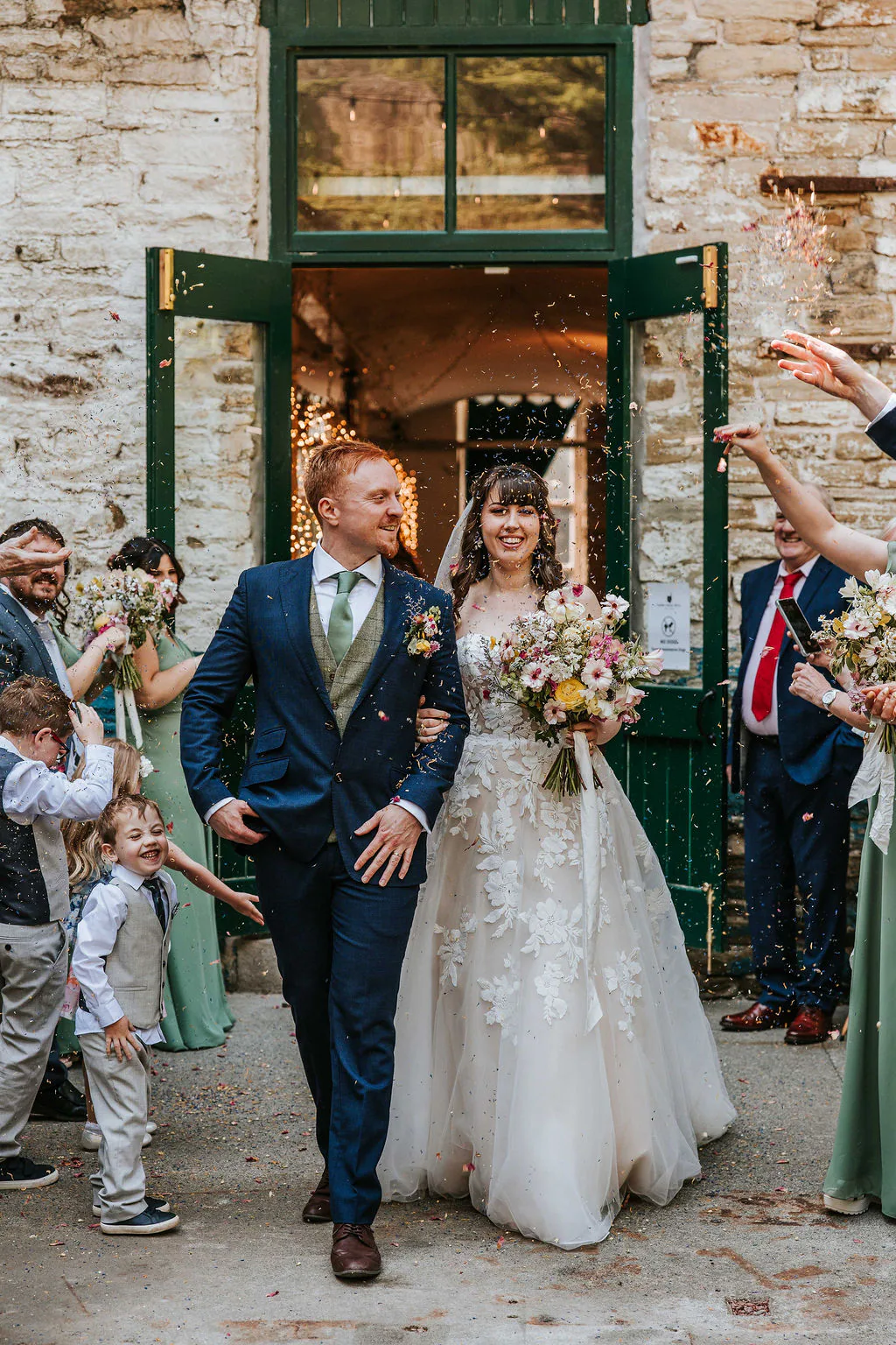 Chloe and Pete walking through confetti after their ceremony