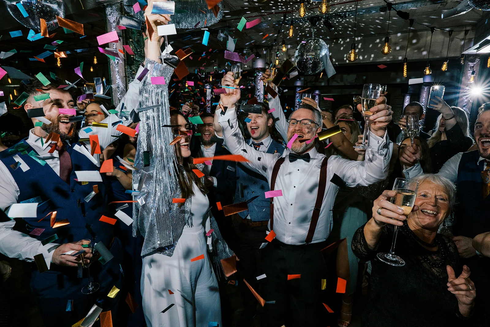 Emma and Rich celebrating at midnight beneath falling confetti