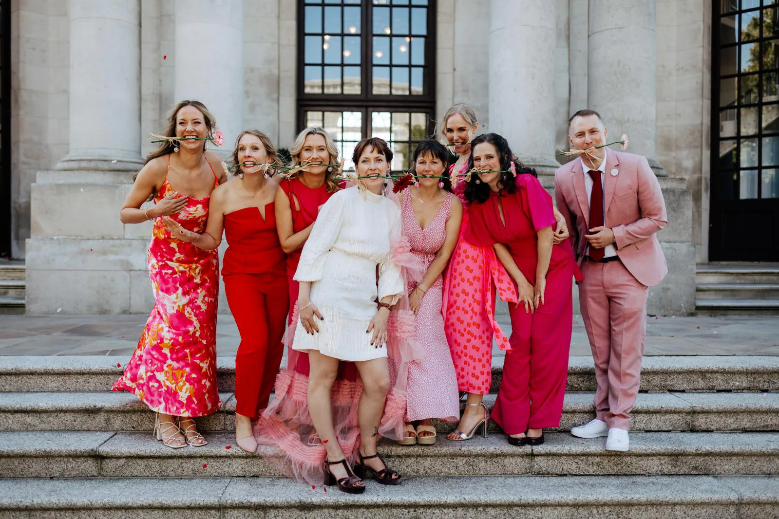 Kat and Dan surrounded by their colourful wedding party