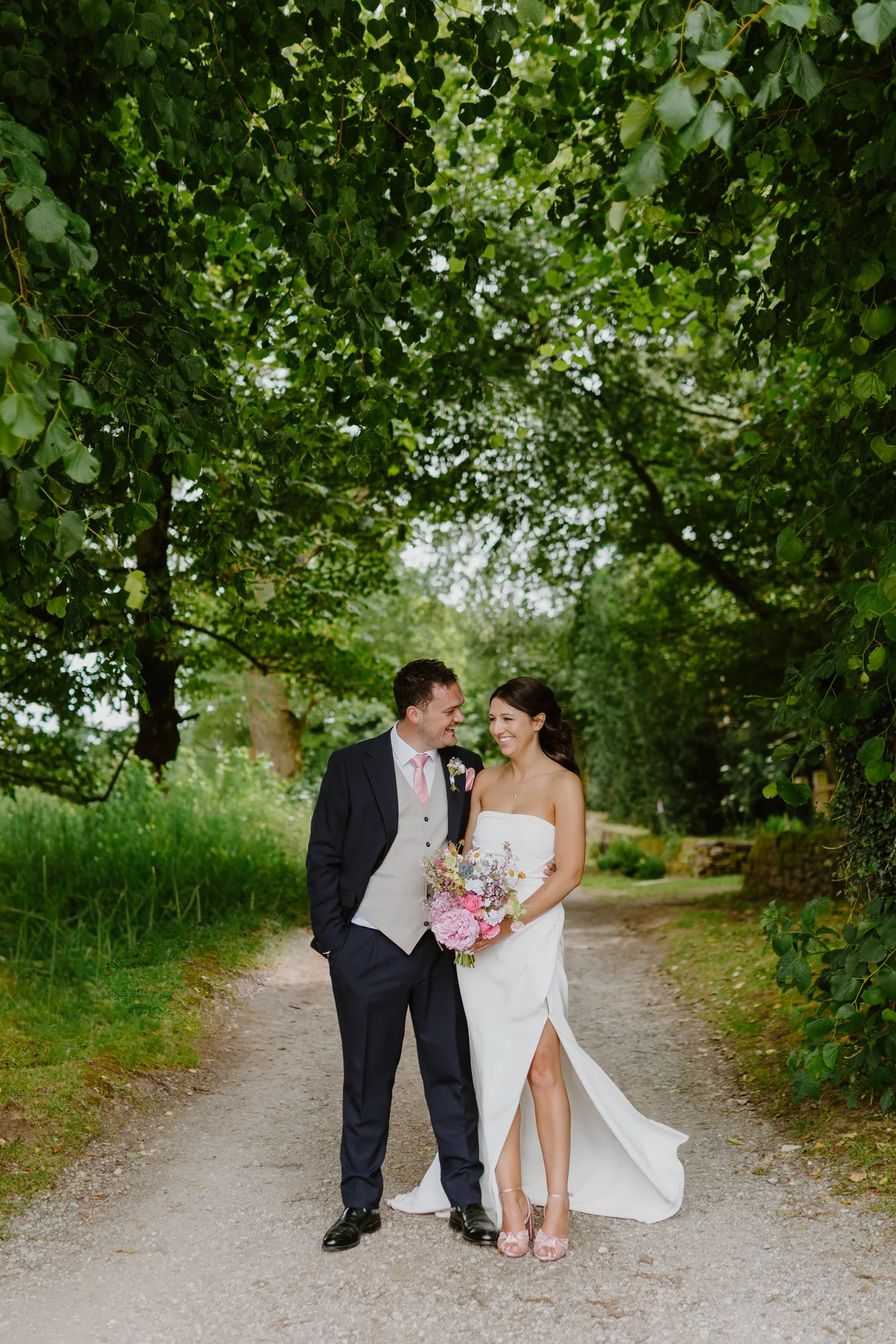 Lizzie and Matt smiling together beneath the trees