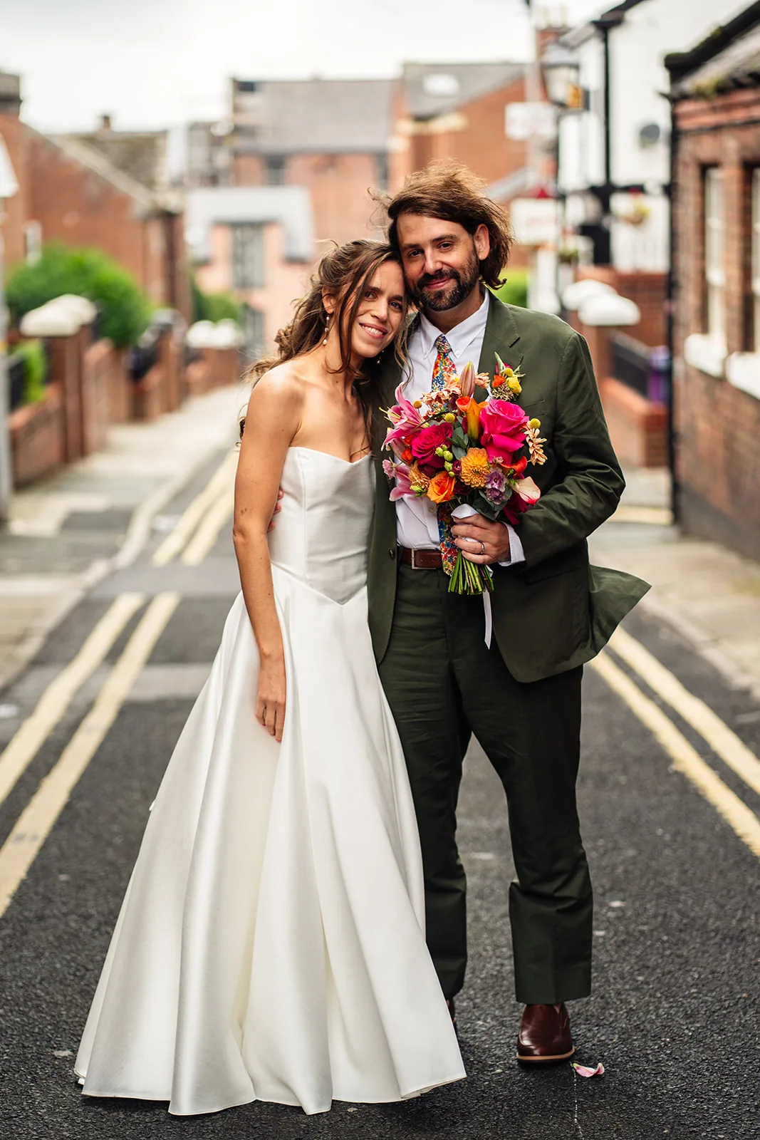 Mark and MJ standing together with a vivid wedding bouquet
