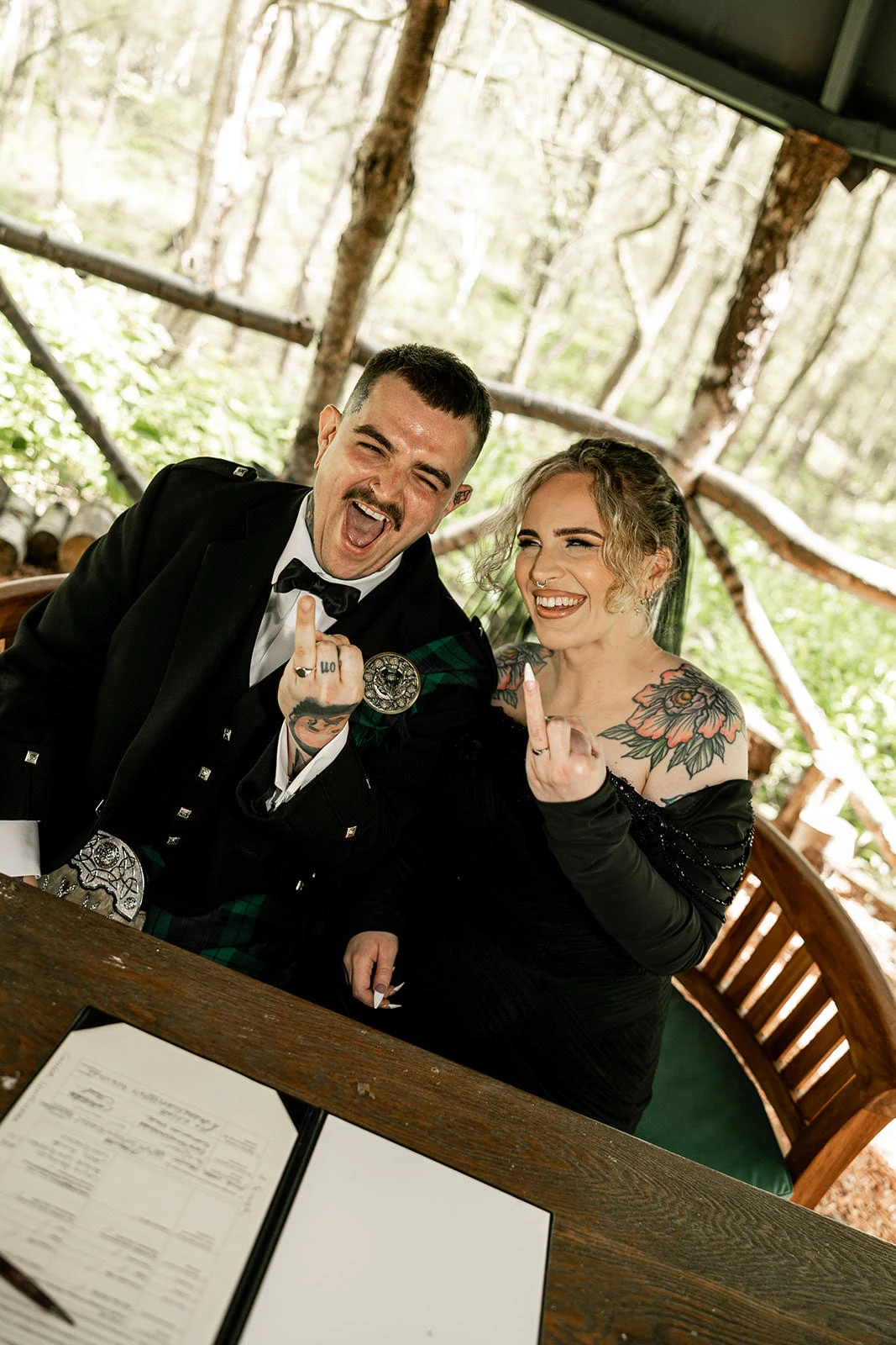 Alice and Connor smiling together and showing their wedding rings