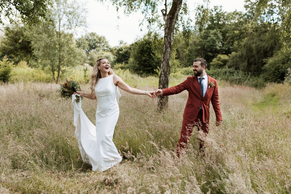 Mark and Jules holding hands in a field